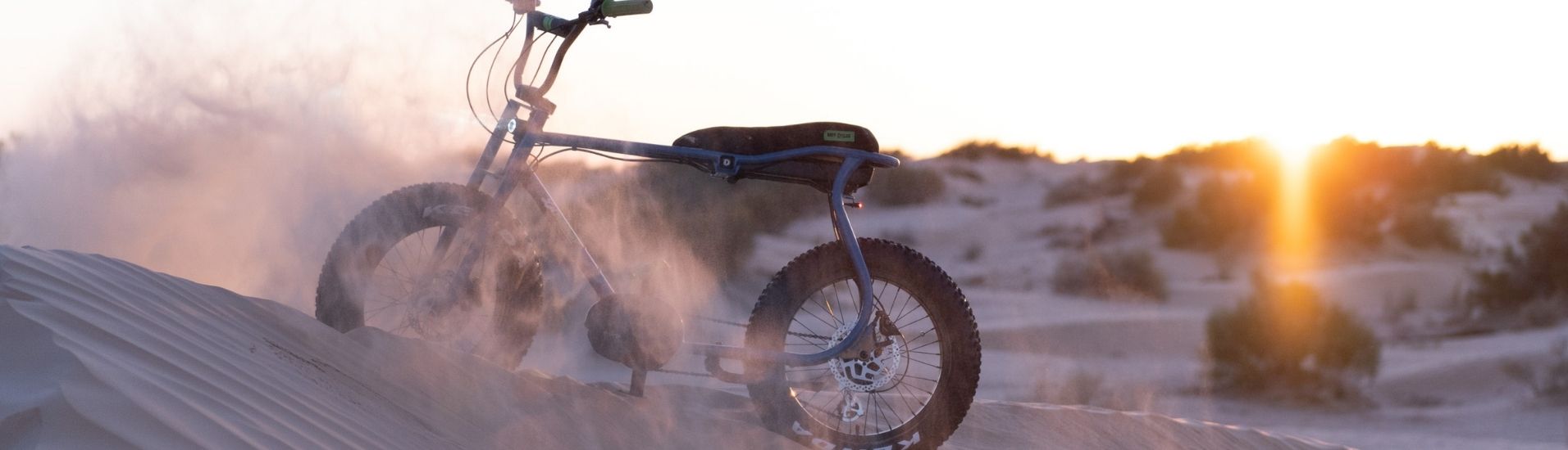 Lil Buddy E-Bike im Sand mit Sonnenuntergang