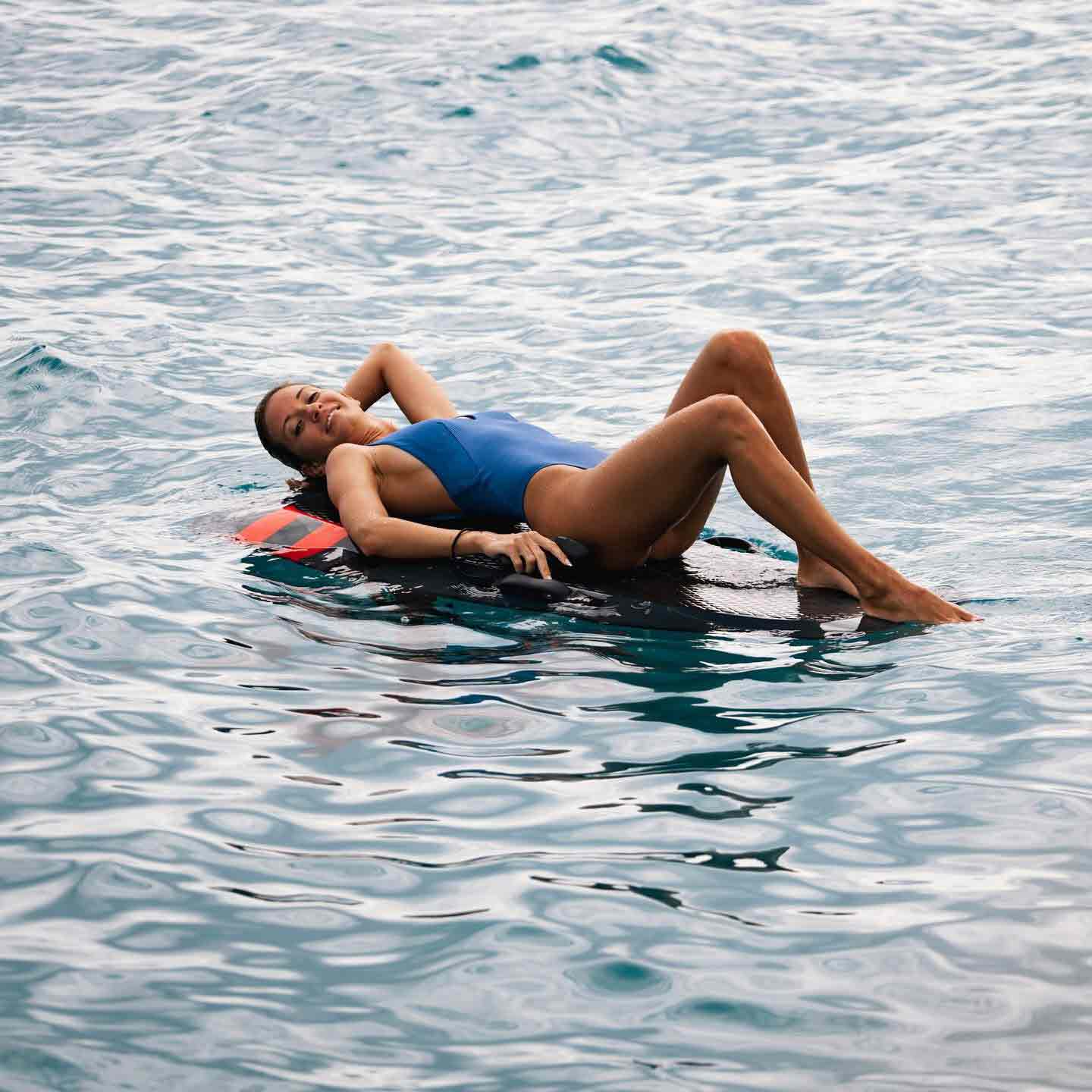 Frau auf Surfbrett liegend